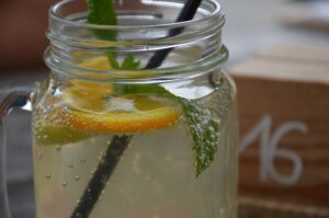 Refreshing lemonade with lemon balm in a mason jar, garnished with a sprig of lemon balm and a slice of lemon, a natural relaxant.