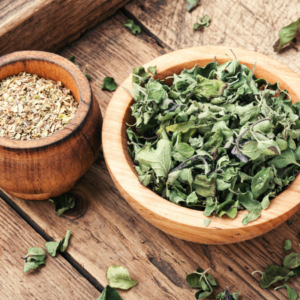 : Wooden bowls filled with dried fennel and other herbs on a rustic wooden surface.