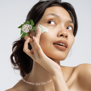 marshmallow root cream to their face with a marshmallow flower tucked behind their ear.